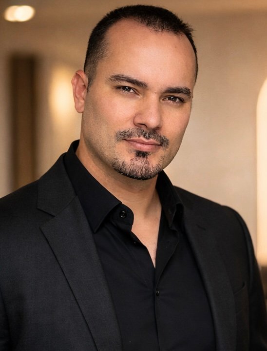 Rey in a black suit, founder of RG Hair by Rey
